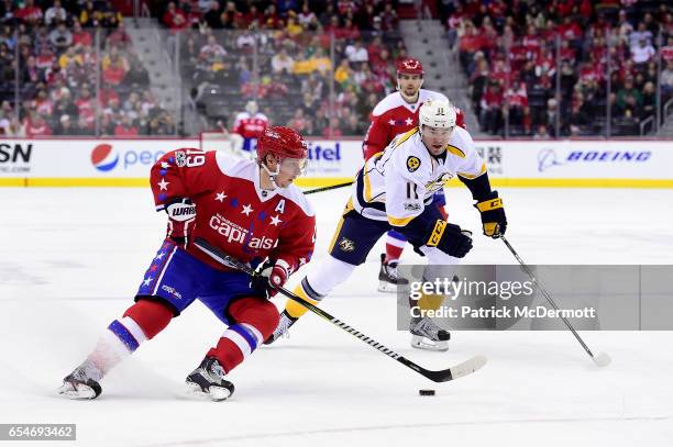 Nicklas Backstrom of the Washington Capitals skates with the puck against PA Parenteau of the Nashville Predators in the first period during an NHL...