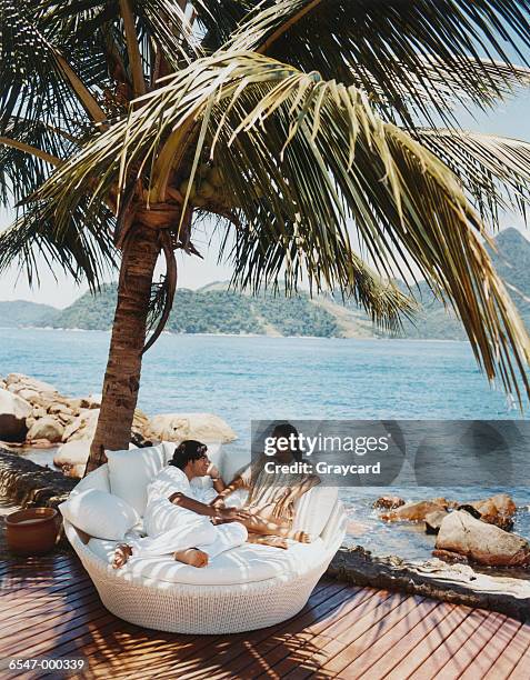 couple sitting by ocean - angra dos reis ストックフォトと画像