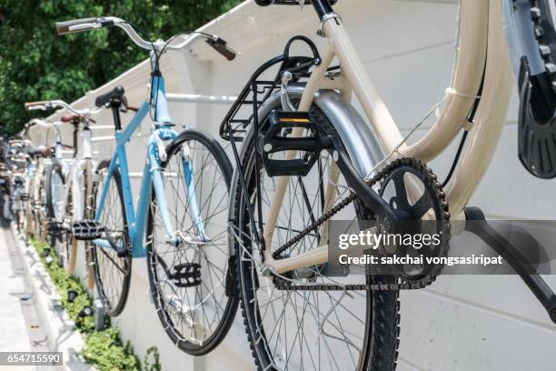 bicycles parket by wall at night - parket foto e immagini stock