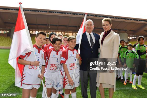 Prince Albert II of Monaco and Princess Charlene of Monaco pose with the Under-12 Rugby team of Monaco prior the Sainte Devote Rugby Tournament on...