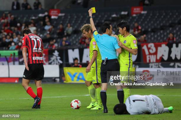 Hidetaka Kanazono of Consadole Sapporo is shown a yellow card by referee Hiroyuki Kimura during the J.League J1 match between Consadole Sapporo and...