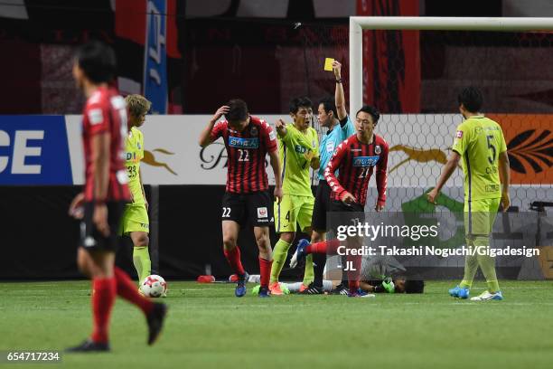 Hidetaka Kanazono of Consadole Sapporo is shown a yellow card by referee Hiroyuki Kimura during the J.League J1 match between Consadole Sapporo and...