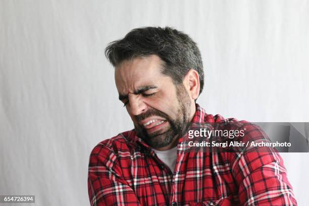 extremely expressive guy in his late 30s: disgusted or aching - offensive stockfoto's en -beelden
