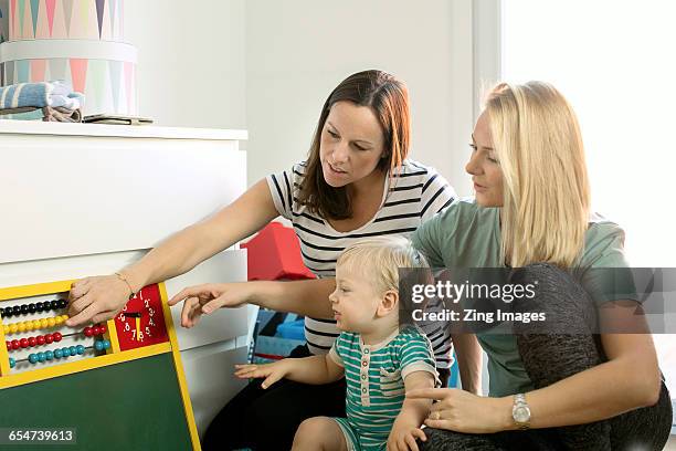 female couple playing with baby boy - leaninlgbt stock pictures, royalty-free photos & images