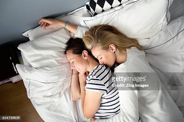 female couple embracing on bed - lesbian bed stock pictures, royalty-free photos & images