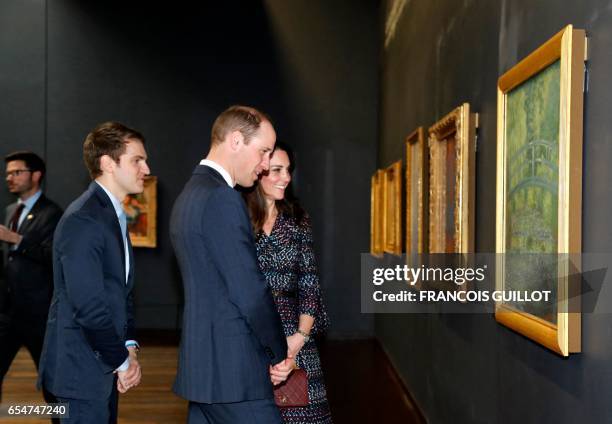 Britain's Prince William, Duke of Cambridge, and his wife Britain's Kate, Duchess of Cambridge, look at a painting by Claude Monet 'Nympheas Water...