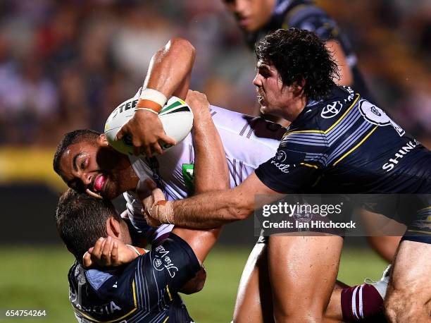 Dylan Walker of the Sea Eagles is tackled by Jake Granville and Benjamin Hampton of the Cowboys during the round three NRL match between the North...