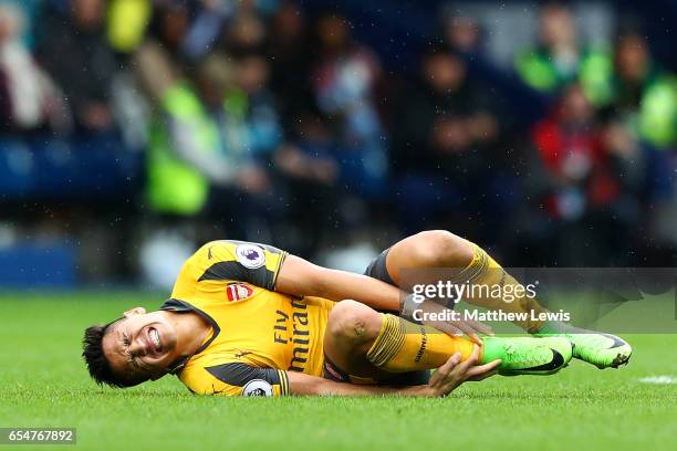 Alexis Sanchez of Arsenal goes down in pain during the Premier League match between West Bromwich Albion and Arsenal at The Hawthorns on March 18,...