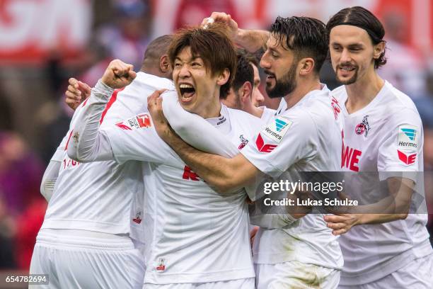 Yuya Osako of Koeln celebrates his teams first goal with Dominic Maroh and Neven Subotic of Koeln during the Bundesliga match between 1. FC Koeln and...