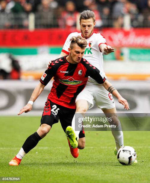 Maximilian Philipp of Freiburg is challenged by Jeffrey Gouweleeuw of Augsburg during the Bundesliga match between FC Augsburg and SC Freiburg at WWK...