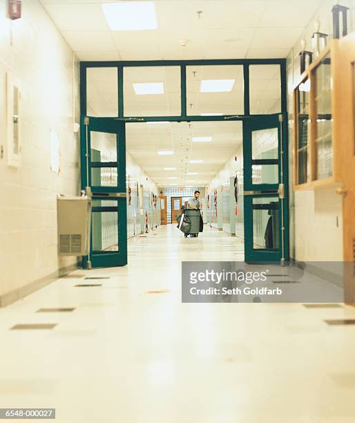 janitor in school corridor - bidello foto e immagini stock