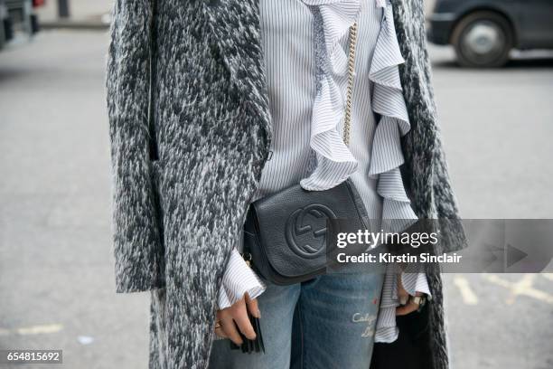 Fashion blogger Camila Carril wears a Haizhen Wang coat, Levi's jeans, Sister Jane shirt and Gucci bag on day 5 of London Womens Fashion Week...