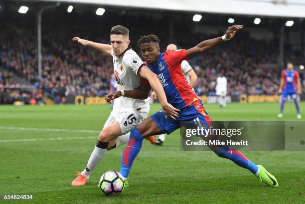 Craig Cathcart of Watford and Wilfried Zaha of Crystal Palace battle for possession during the Premier League match between Crystal Palace and...