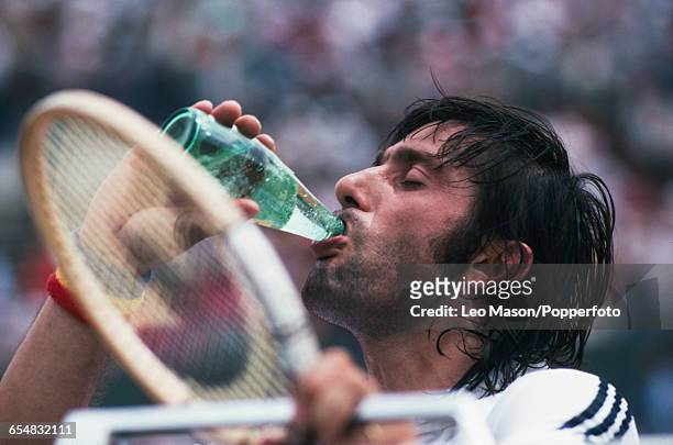 Romanian tennis player Ilie Nastase pictured drinking a bottle of mineral water during competition to be knocked out in the first round of the Men's...