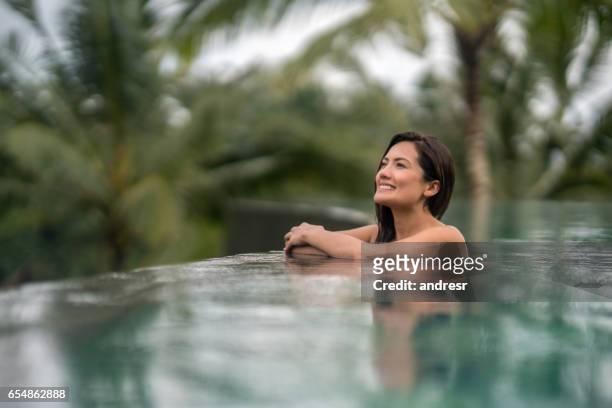 mooie vrouw ontspannen in het zwembad - infinity pool stockfoto's en -beelden