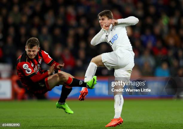 Tom Carroll of Swansea City shoots while Ryan Fraser of AFC Bournemouth attempts to block during the Premier League match between AFC Bournemouth and...