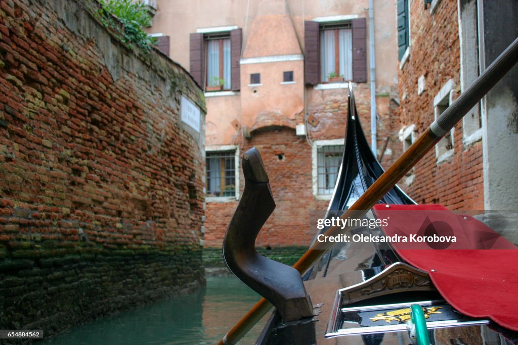 Traveling down the canals in Venice from the point of view of a person in the gondola