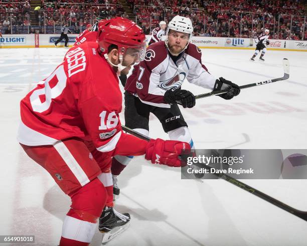 Robbie Russo of the Detroit Red Wings takes a hit from John Mitchell of the Colorado Avalanche during an NHL game at Joe Louis Arena on March 18,...