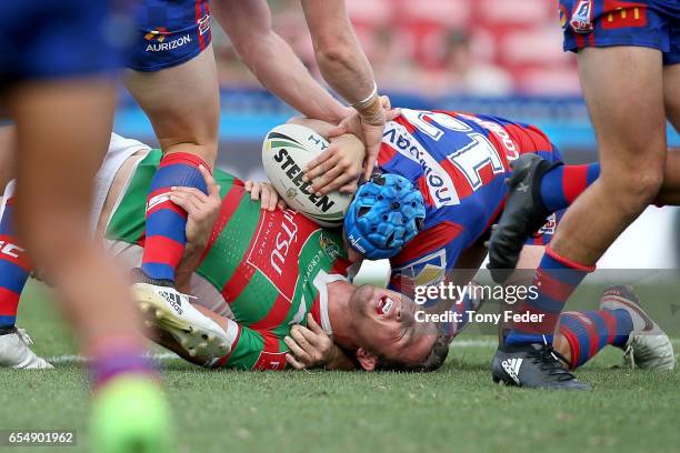 Sam Burgess of the Rabbitohs is tackled by Jamie Buhrer of the Knights during the round three NRL match between the Newcastle Knights and the South...