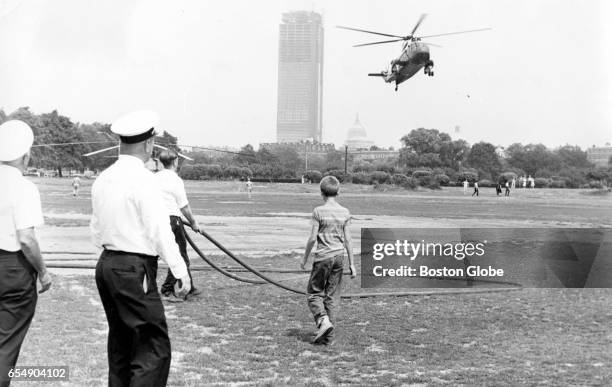 Firemen stand by as President John F. Kennedy's helicopter lands at Fens Stadium in Boston, Aug. 8, 1963. The president's prematurely born son,...