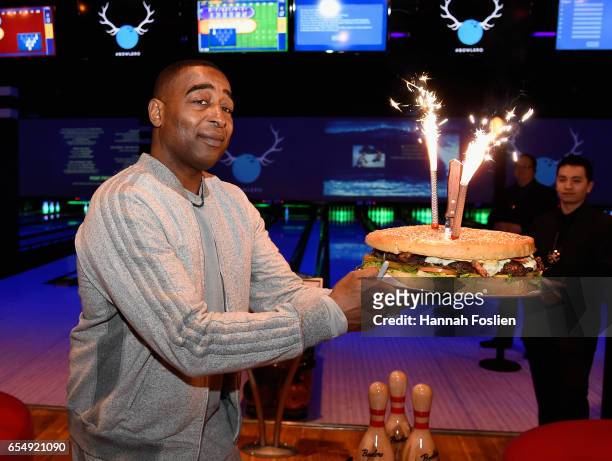 Cris Carter shows off a Behemoth Burger at the Grand Opening of Bowlero Lakeville on March 18, 2017 in Lakeville, Minnesota.