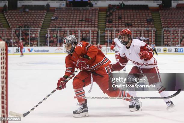Ohio State Buckeyes forward Christian Lampasso and Wisconsin Badgers defenseman Jake Linhart skate after the puck during the first period of a Big 10...