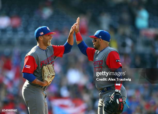 Juan Carlos Romero of Team Puerto Rico celebrates with Rene Rivera after winning Game 5 of Pool F of the 2017 World Baseball Classic against Team...