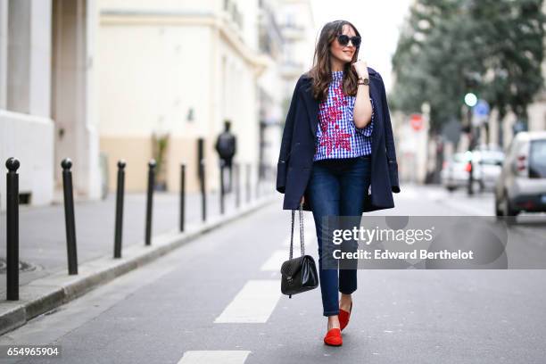 Sarah Benziane, fashion blogger, wears a Pimkie coat, a Zara floral print top, Bonobo jeans, Zara shoes, and a black leather bag, on March 18, 2017...