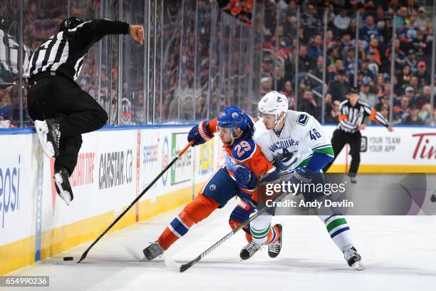 Leon Draisaitl of the Edmonton Oilers battles for the puck against Jayson Megna of the Vancouver Canucks on March 18, 2017 at Rogers Place in...