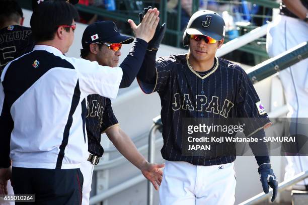 Kosuke Tanaka of Japan hits a single celerates after scoring in the top half of the eigth inning during the exhibition game between Japan and Chicago...