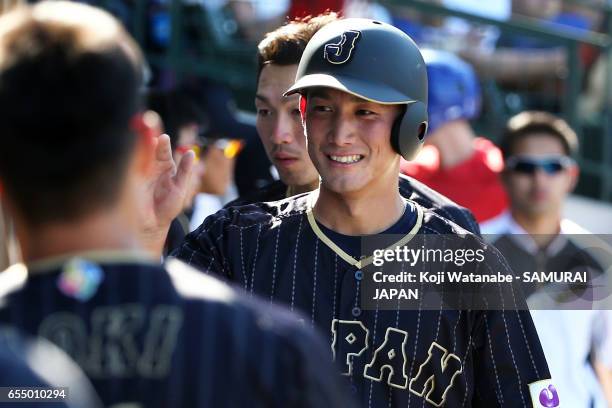 Seiji Kobayashi of Japan hits a single celerates after scoring in the top half of the eigth inning during the exhibition game between Japan and...