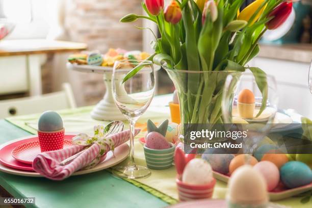 kleurrijke ingerichte pasen couvert - paastafel stockfoto's en -beelden