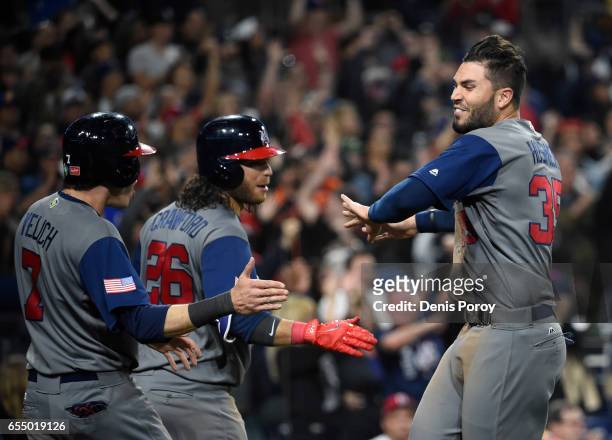 Eric Hosmer of the United States, right, is congratulated by Brandon Crawford, and Christian Yelich after scoring during the eighth inning of the...