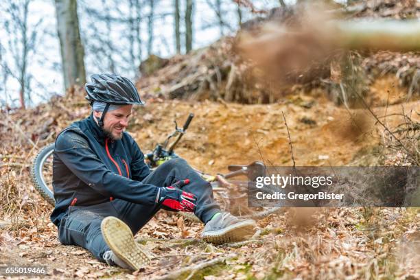 young man fell off mountain bike - leisure equipment stock pictures, royalty-free photos & images