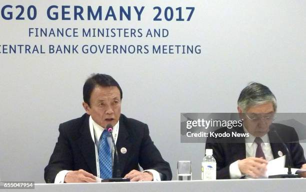 Japanese Finance Minister Taro Aso and Bank of Japan Governor Haruhiko Kuroda attend a news conference in Baden-Baden, Germany, on March 18 after the...