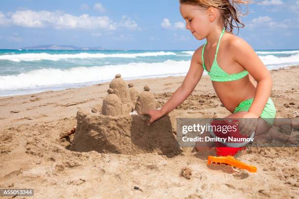 girl building a sandcastle on a beach - heraklion stock pictures, royalty-free photos & images