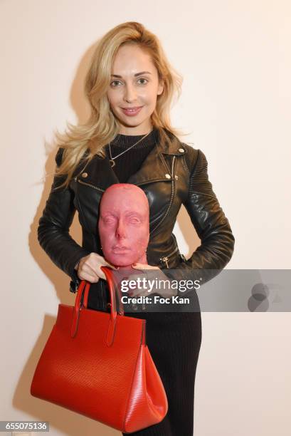 Bags and scarves designer Sasha Berry poses with Sarah Trouche's chocolate face sculpture during the 'Faccia A Faccia' Sarah Trouche performance...