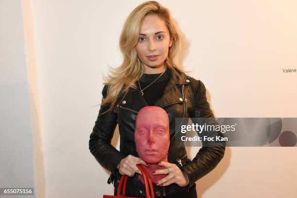 Bags and scarves designer Sasha Berry poses with Sarah Trouche's chocolate face sculpture during the 'Faccia A Faccia' Sarah Trouche performance...