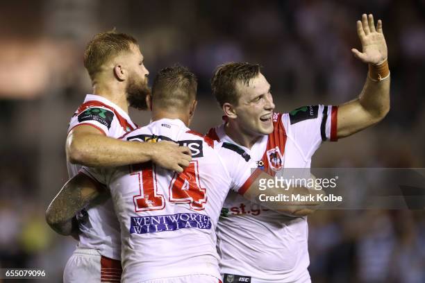 Jack de Belin, Tariq Sims and Jacob Host of the Dragons celebrate victory during the round three NRL match between the Cronulla Sharks and the St...