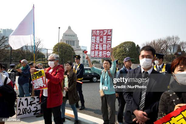 Anti-Shinzo Abe protesters holds a placards in front of Tokyo parliament during a rally, denouncing his government policies and calling on the...