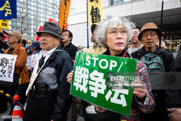 Anti-Abe protesters gather with placards in front of Tokyo parliament during a rally, denouncing his government policies and calling on the Japanese...