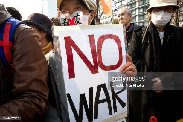 Anti-Abe protesters gather with placards in front of Tokyo parliament during a rally, denouncing his government policies and calling on the Japanese...
