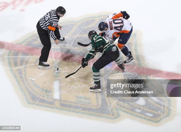 Ryan Moore of the Flint Firebirds takes a faceoff against Cliff Pu of the London Knights during an OHL game at Budweiser Gardens on March 17, 2017 in...