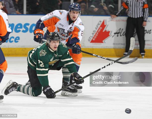 Alex Peters of the Flint Firebirds battles for a loose puck against Janne Kuokkanen of the London Knights during an OHL game at Budweiser Gardens on...