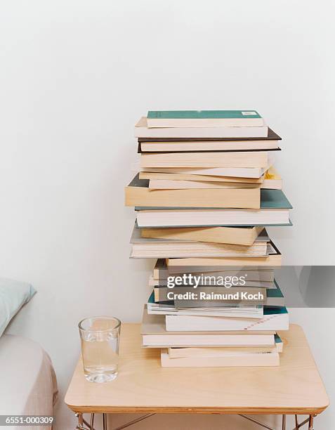 stack of books on night table - paperback stock pictures, royalty-free photos & images