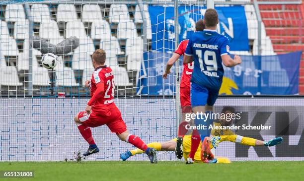 Rouwen Hennings of Fortuna Duesseldorf scores the first goal for his team against Dirk Orlishausen of Karlsruhe during the Second Bundesliga match...
