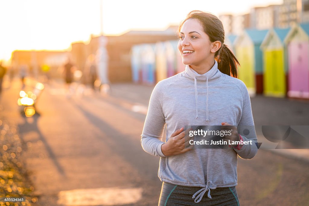 WOMAN RUNNING ALONG BEACHFRONT