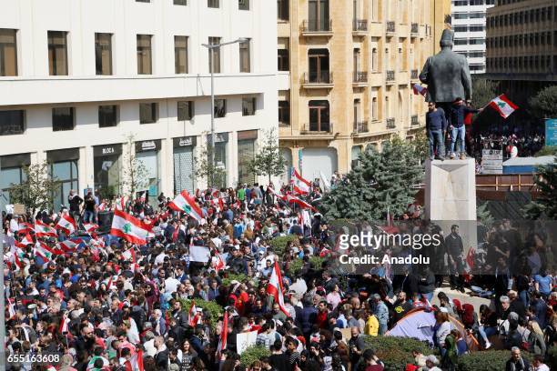Lebanese people wave Lebanese flags as they gather at Riad Al Solh Square to protest the corruption and the government's new tax plans in Beirut,...