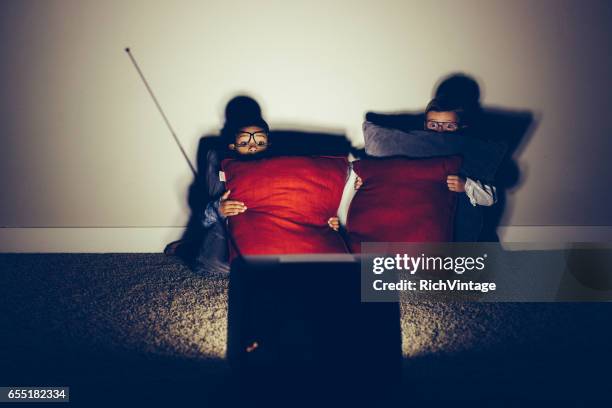 two scared nerds watching horror movie late at night - filme de terror imagens e fotografias de stock