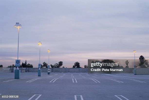 empty parking lot at dusk - parking stock pictures, royalty-free photos & images